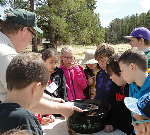 man educating a group of children outdoors