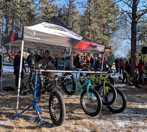 several bicycles and a tent with people outside